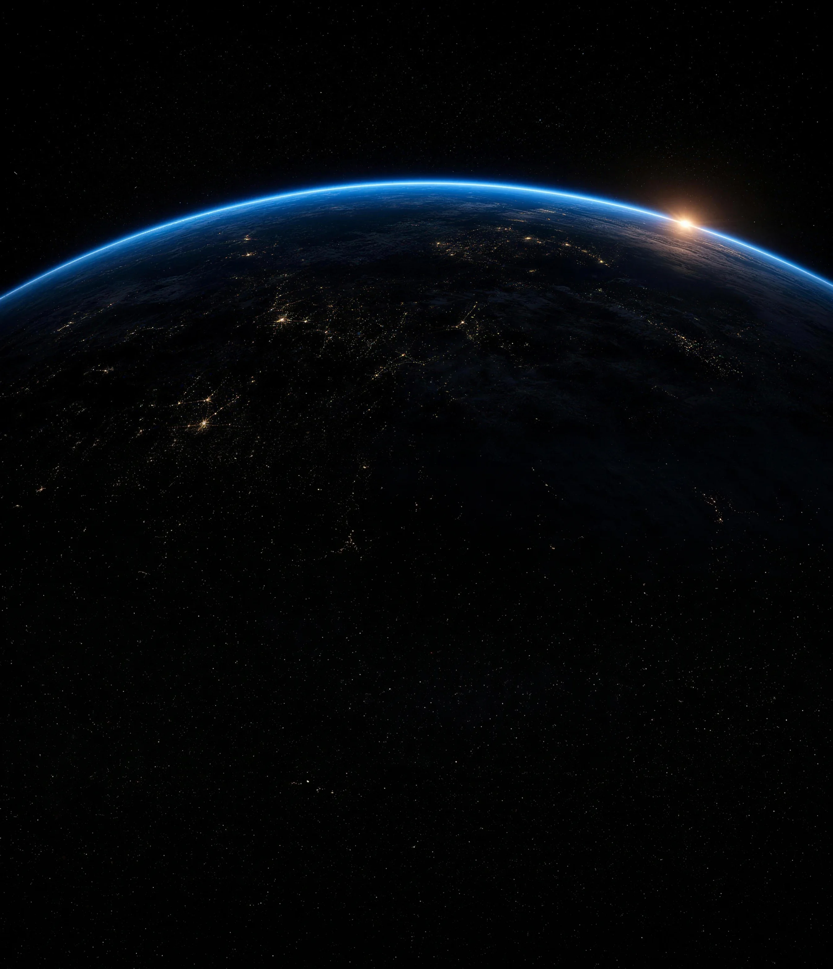 The curve of the Earth seen from orbit at night: a thin band of blue atmosphere along the horizon, faint city lights on the dark surface below it and the first light of sunrise at the right end of the curve